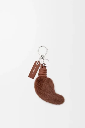 Charm i form av en lejonsvans i mink och kalvskinn